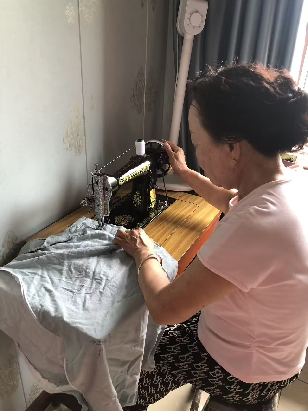 外婆坐在缝纫机前操作