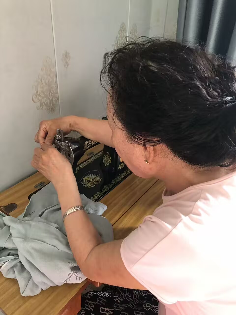 外婆的手在调整缝纫机压脚